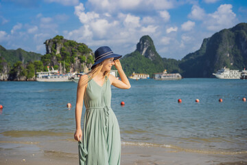 Attractive woman in a dress is traveling in Halong Bay. Vietnam. Travel to Asia, happiness emotion, summer holiday concept. Picturesque sea landscape. Ha Long Bay, Vietnam