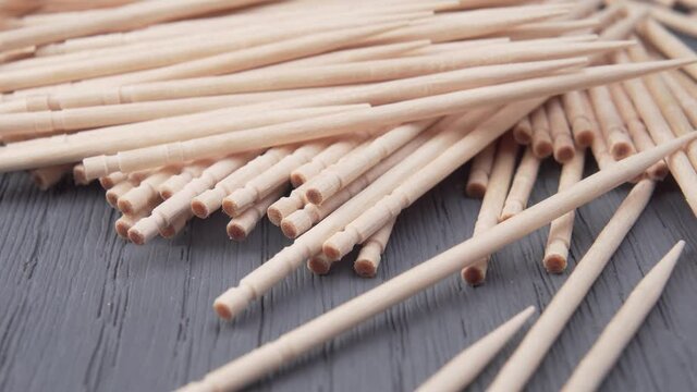 Bunch of toothpicks on a wooden surface. Macro. Dolly Shot