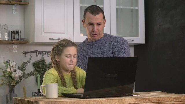 Happy family. Parent helps her daughter do her homework for school. Online learning concept. Smiling parent helping daughter with task. Happy family on online education. New school online learning