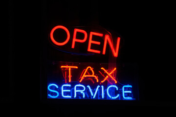 'TAX SERVICE' neon sign on black background 