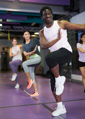 Portrait of excited man dancing during group class in dance center