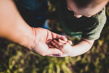 Baby giving the hand to his father