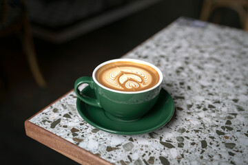 Cup of Flat White coffee in a green cup with beautiful latte art.