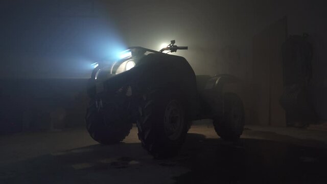 Smokey dark garage circling around an atv quad with newly installed LED lights on the grill.