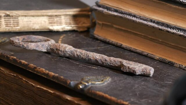 Rusty key and old books evocating religious concept about life. Close-up