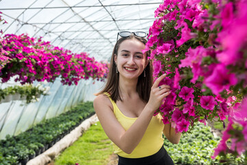 female buyer chooses beautiful flowers in a greenhouse