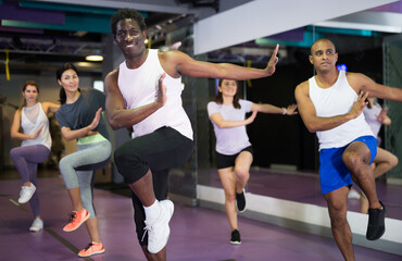 Portrait of excited man dancing during group class in dance center