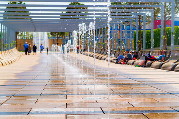 Obraz premium Row of fountains in a park at a high shutter speed freezing the motion of the water and suspended droplets with variety of shape, like a crystal or ice isolated with beautiful bokeh