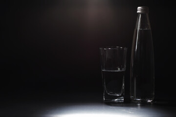 Close up pouring purified fresh drink water from the bottle on table in living room. Drinking water. Mineral vitamin water. Healthy, mineral-rich, refreshing water.