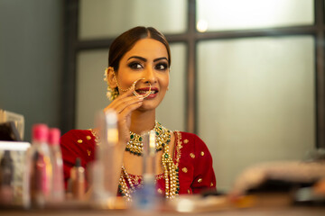 Indian Bride during the makeup session looking in to the mirror