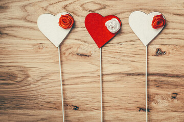 red and white hearts with sticks on wooden table background.