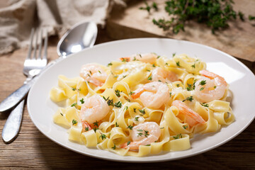 plate of pasta fettuccine with cream sauce and shrimps