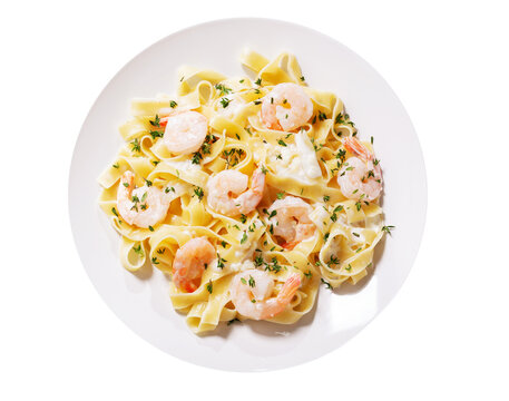 plate of pasta fettuccine with cream sauce and shrimps isolated on a white background