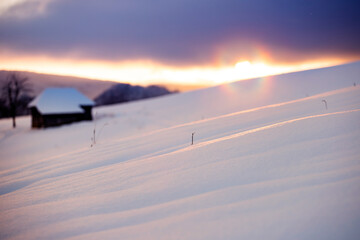 Small cottage in magic sunset in winter mountains