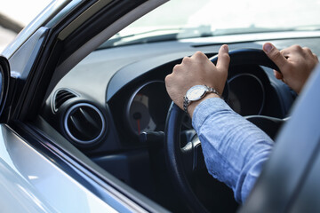 Handsome man with stylish wristwatch driving car