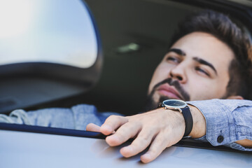 Handsome man with stylish wristwatch driving car