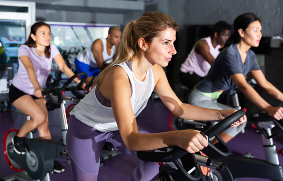 Female cycling on exercise bikes at fitness club. High quality photo