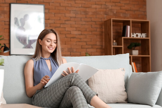 Beautiful Woman Reading Blank Magazine In Living Room