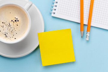 Obraz na płótnie Canvas Office desk with yellow sticker, coffee and supplies