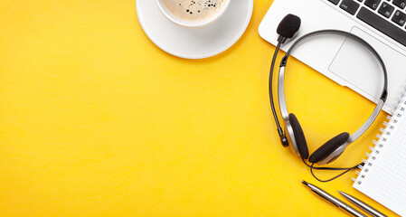 Office desk with headset, coffee and laptop. Work from home