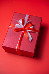 Red gift box with white and red bow on red background top view, Valentines day, Flat lay style with copy space.