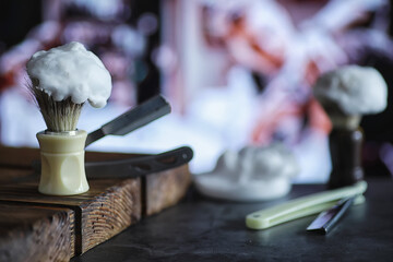 Shaving accessories on a wooden texture background. Tools. Disposable shaving machine, brush, foam and hazard razor.