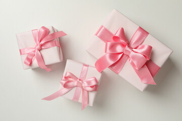 Gift boxes with pink ribbon on white background