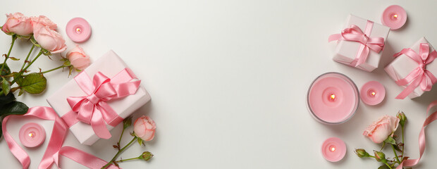 Fototapeta na wymiar Concept of Valentine's day with roses, gift boxes and candles on white background