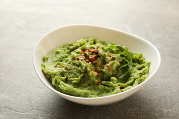Bowl of guacamole on gray background, close up