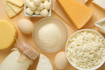 Different fresh dairy products on beige background, top view