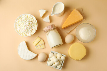 Different fresh dairy products on beige background, top view