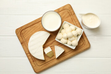 Board with different dairy products on wooden background
