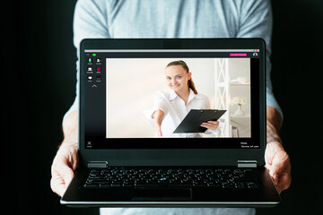 Virtual meeting. Business webinar. Distance learning. Online interview. Successful female leader greeting with handshake from screen on laptop man holding isolated on black.