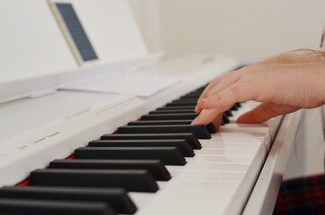 Fototapeta na wymiar Childrens fingers press the piano keys.