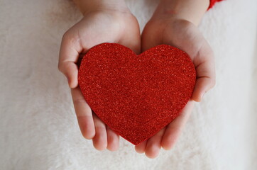 Hands holding a red heart/