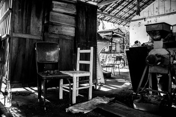 Obraz premium Abandoned pile of paraphernalia (wardrobe, chairs, machines and so forth) at a shed [Black and White] 