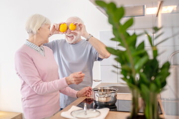 Senior couple cooking together in the kitchen and feeling good