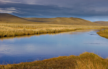 Pampas landscape with river and rolling hills on Tierra del Fuego in autumn