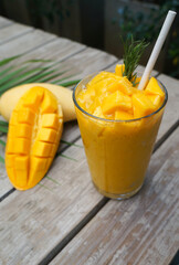 Mango Smoothie With fresh mango in a glass placed on a wooden table