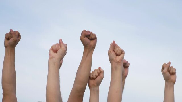 Teamwork. A group of people against the sky raises their hands up. The concept of voluntary voting, expression of consent, support for democracy.