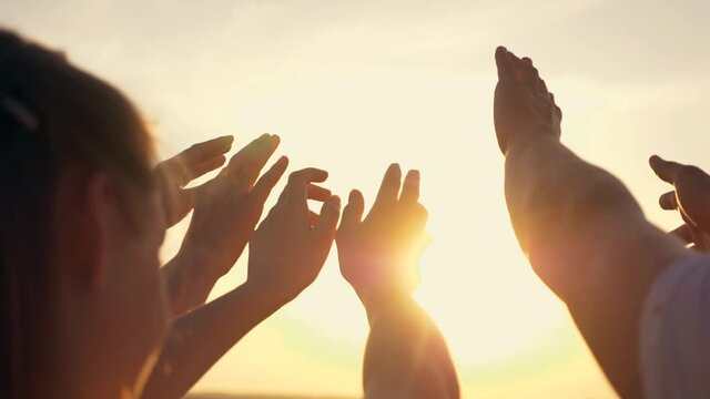 People's hands reach out to the sun and god at sunset. Happy family together hands up religion. Teamwork. Prayer for help. People turn to God together in prayer. People in religion. Helping hand sun