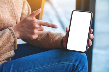 Mockup image of a woman pointing finger at a mobile phone with blank white screen