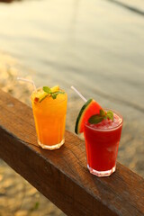 Orange and watermelon smoothies served on a wooden table 