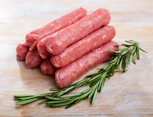 Traditional Catalan raw pork sausage botifarra ready for grilling on wooden board..