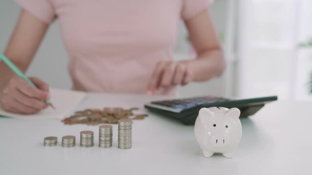 Women are calculating money to save for the future. Saving money is the beginning of an investment for investing and is used in the elderly. The concept of saving for the future.