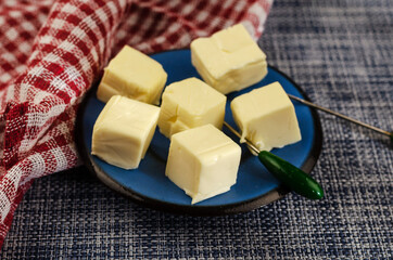 Processed cheese sliced into portions in a blue sauc