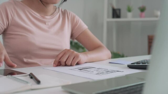 woman is review debt invoice and use mobile phone a scanning to pay invoice. Women work from home and spend online to reduce their risk of communicable diseases. concept of social distance online.