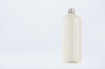 Transparent plastic tall bottle with pale fresh drink or cosmetic essential oil, silver cap mockup on white background. Template for portfolio, design, branding identity.