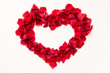 Beautiful heart of red rose petals on white background