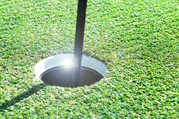 Golf with Flagstick and hole on putting green on golf course 